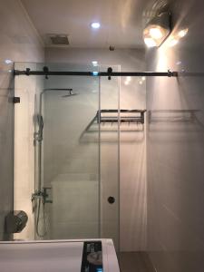 y baño con ducha y puerta de cristal. en SAOLA Apartment & Hotel en Dong Ra