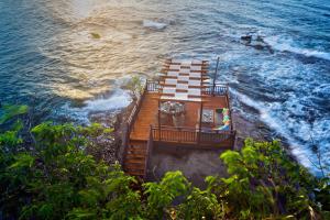 une terrasse en bois sur la rive de l'océan dans l'établissement Cap Maison Resort & Spa, à Cap Estate