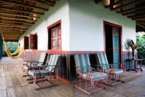 a group of chairs sitting outside of a building at Finca La Argelia in Quimbaya