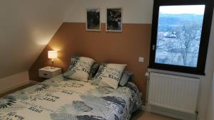 a bedroom with a bed with pillows and a window at Aux chataigniers alpins in Gap