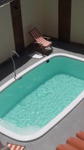 a jacuzzi tub with a chair and a chair at Pousada Pelourinho in Mucuri