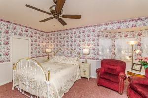 a bedroom with a bed and a red chair at Apples Bed and Breakfast Inn in Big Bear Lake
