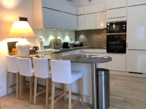 a kitchen with a table with chairs and a lamp at Le cabanon in Antibes