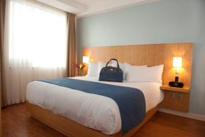 Postel nebo postele na pokoji v ubytování The Holman Grand Hotel