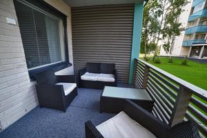 a balcony with two chairs and a bench and a table at JK Apartment Jannela in Lapua