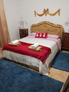 um quarto com uma cama grande com lençóis e almofadas vermelhos e brancos em B&B Chez Elisabeth em Pádua