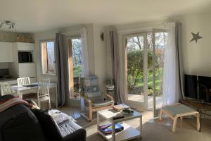 uma sala de estar com um sofá e uma televisão em Le Montbonnot Luminous T2 Garden - Terrace #P0 em Montbonnot-Saint-Martin