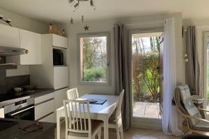 a kitchen with a table and chairs and a window at #P0 Le Montbonnot Luminous T2 Garden - Terrace in Montbonnot-Saint-Martin +16 photos
