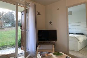 um quarto com uma televisão, uma cama e uma janela em Le Montbonnot Luminous T2 Garden - Terrace #P0 em Montbonnot-Saint-Martin