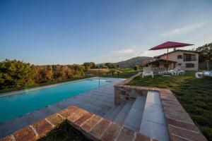 a swimming pool with a patio and a house at Agriturismo La Spiga D'Oro in Frontino