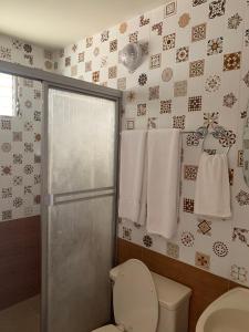 een badkamer met een toilet, een douche en handdoeken bij HOTEL CARISABEL in Aguadulce