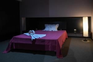 a bedroom with a purple bed with two towels on it at La Torre-1984 in Sarnelli