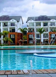 a pool with a fountain in front of some buildings at 396 The Blyde Crystal Clear Lagoon 2 Bedroom Penthouse Apartment in Pretoria