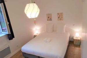a bedroom with a white bed with two towels on it at #F2 The patioGarden Free parking in Saint-Martin-dʼHères