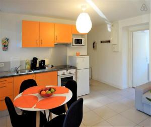 a kitchen with a table with a bowl of fruit on it at #F2 The patioGarden Free parking in Saint-Martin-dʼHères