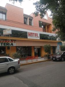 un edificio de hotel con coches estacionados frente a él en H MEXICANA DE MÁRMOL, en Tehuacán