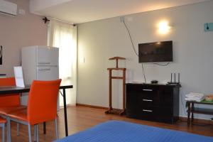 Habitación con cama, escritorio y TV. en MendoApart en Mendoza
