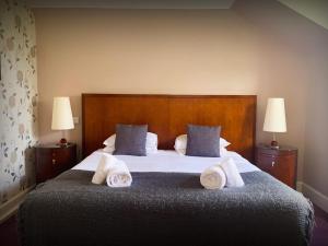 a bedroom with a large bed with towels on it at The Speyside Hotel and Restaurant in Grantown on Spey
