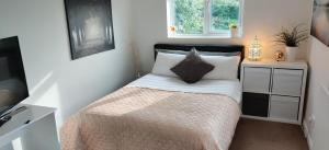 Habitación pequeña con cama y ventana en Freemantle Solent Lodge SGH, en Southampton