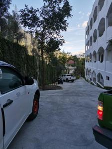 een witte auto geparkeerd op een parkeerplaats naast een gebouw bij Pescador Hotel PH in Santiago Atitlán