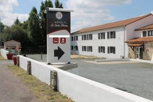 een bord voor een gebouw naast een weg bij Hôtel Le Sainte Florence in Sainte-Florence