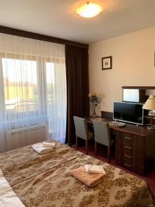 Habitación de hotel con cama, escritorio y TV. en Apartamenty Arka Medical Spa **** en Kołobrzeg