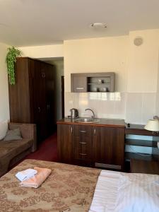 a room with a bed and a sink and a kitchen at Apartamenty Arka Medical Spa **** in Kołobrzeg