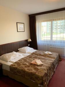 a hotel room with a bed with two towels on it at Apartamenty Arka Medical Spa **** in Kołobrzeg