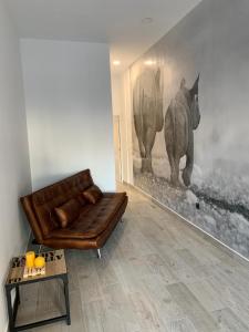 - un salon avec un canapé et une photo d'éléphants dans l'établissement T-Homes - Fuencarral, à Madrid