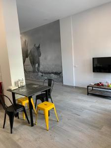 a dining room with a black table and yellow chairs at T-Homes - Fuencarral in Madrid