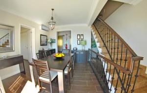 a kitchen and dining room with a table and stairs at Apartamentos 3 Praias in Ponta Delgada