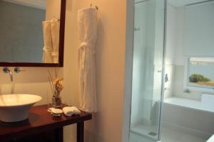 a bathroom with a sink and a glass shower at Hotel Territorio in Puerto Madryn