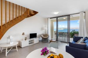 a living room with a blue couch and a table at Almyrida Panorama II BY APOKORONAS-VILLAS in Almirida