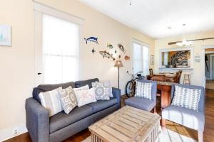 a living room with a couch and two chairs at Castaway Cottage in Galveston