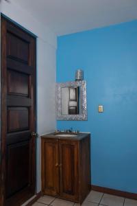 een badkamer met een wastafel en een spiegel aan de muur bij HOTEL NIUT-JA in Oaxaca City