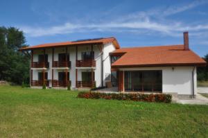 a white house with a red roof and a yard at Popasul din Lunca in Pui +15 photos