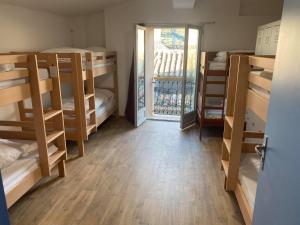 a room with bunk beds and a door to a balcony at Hostel Le Diablotin in Saint-Jean-de-Fos