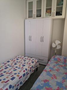 um quarto com uma cama, uma cómoda e um armário em Apartamento Cabo Frio em Cabo Frio