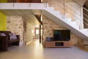 a living room with a tv on a wooden entertainment center at Casa Lucía in Requena