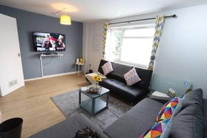 uma sala de estar com um sofá e uma televisão em Family and Contractors HS2 NEC Airport 3beds Homebase em Birmingham