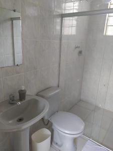 a white bathroom with a toilet and a sink at Vila Marias in Ouro Preto
