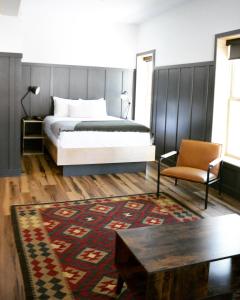a bedroom with a bed and a table and a chair at The Flying Steamshovel Inn in Rossland