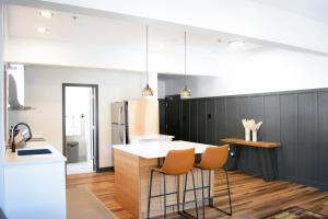 a kitchen with a kitchen island with chairs in it at The Flying Steamshovel Inn in Rossland