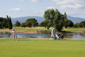 - un groupe de personnes jouant au golf sur un parcours dans l'établissement MOBIL HOME 6 personnes TOUT CONFORT, à Saint-Cyprien