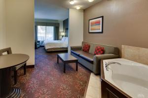 a hotel room with a tub and a couch and a bed at Holiday Inn Express Hotel & Suites Lancaster-Lititz by IHG in Lititz +24 photos