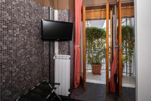 a tv on a wall next to a brick wall at CconfortHotels R&B Dolci Emozioni in Bari