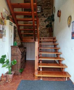 una escalera de madera en una habitación con una pared de ladrillo en Apartamentos Rio Eo, en San Tirso de Abres