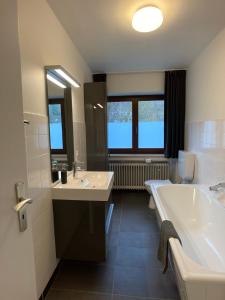 ein Badezimmer mit 2 Waschbecken und einer Badewanne in der Unterkunft Villa Holgenbach - Penthouse- und Ferienwohnung im Nationalpark Eifel in Schleiden