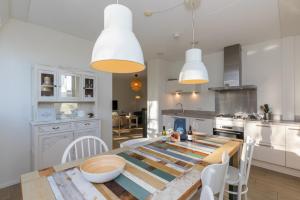 een keuken en eetkamer met een houten tafel en stoelen bij Duinhof Dishoek Luxe appartementen in Dishoek