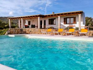 La Sima villa con piscina vista mare San Pantaleo Sardegna في سان بانتاليو: بيت فيه مسبح قدام بيت